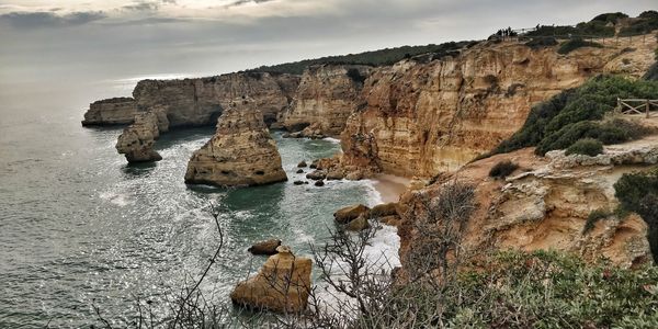 Rock formations by sea against sky