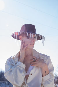 Midsection of woman looking away against sky