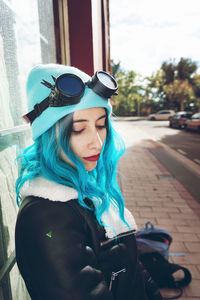 Close-up of fashionable woman with dyed blue hair in city