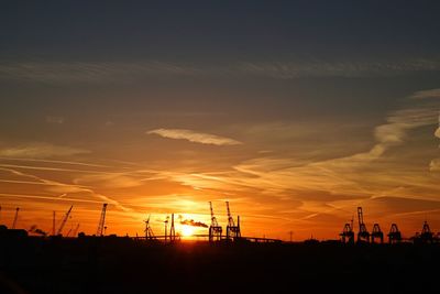 Silhouette of electricity pylon against sky during sunset