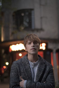 Portrait of young man standing in city
