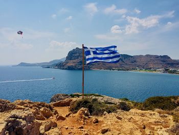 Scenic view of sea against sky with a flag