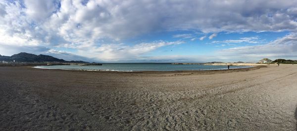 View of beach against cloudy sky