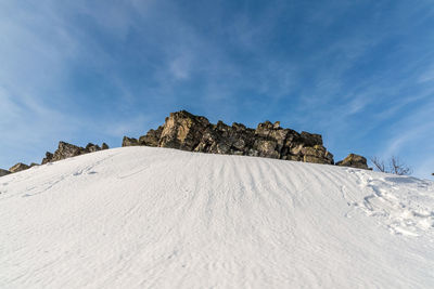 Low angle view of rocky mountain against sky