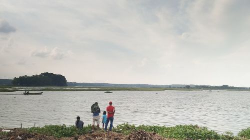 People standing on beach against sky