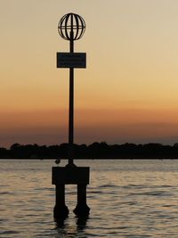 Silhouette pier on sea against sky during sunset