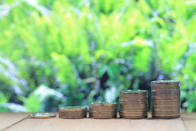 Coin pile stacked in increasing chart shape on wood board. environmental friendly economy.