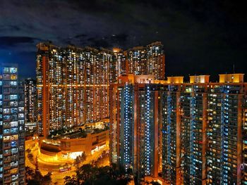 Illuminated buildings against sky at night