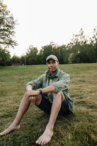 Portrait of man sitting on grass in playground