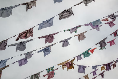 Low angle view of flags hanging against sky