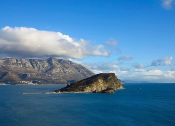 Scenic view of sea and mountains against sky