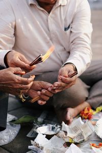 Midsection of man using mobile phone