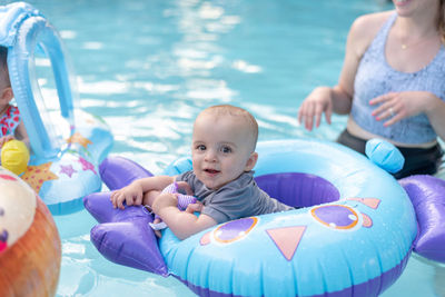 Portrait of cute baby boy with inflatable ring in swimming pool