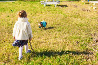 Rear view of woman walking on field