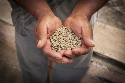 Midsection of man holding coffee beans