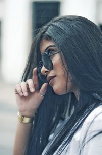 Close-up of woman wearing sunglasses in city