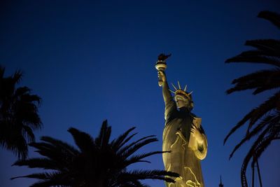 Low angle view of statue of palm tree against blue sky