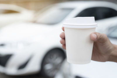 Close-up of hand holding coffee cup