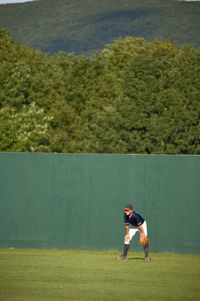 Boy in ready position in the outfield of a baseball field