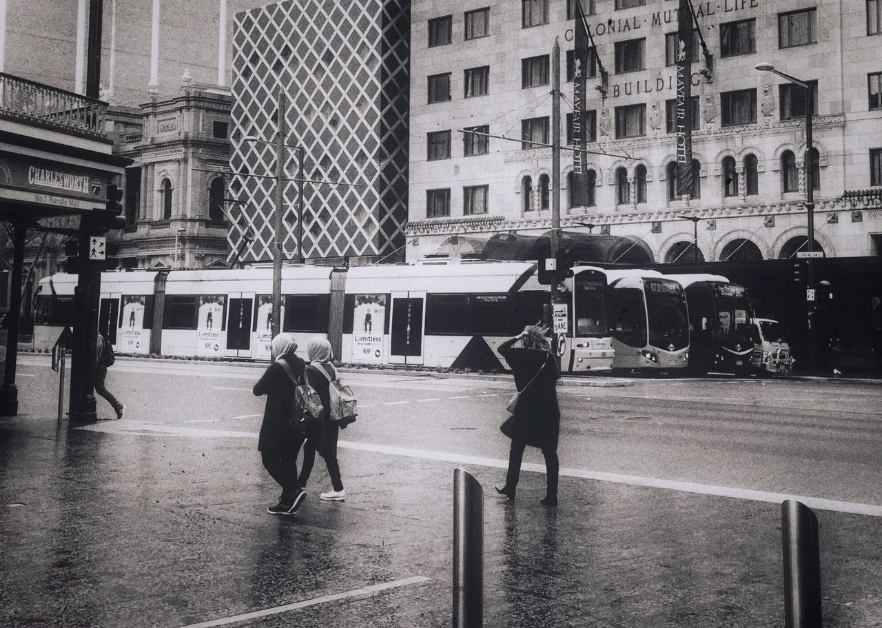 MAN WALKING ON ROAD IN CITY