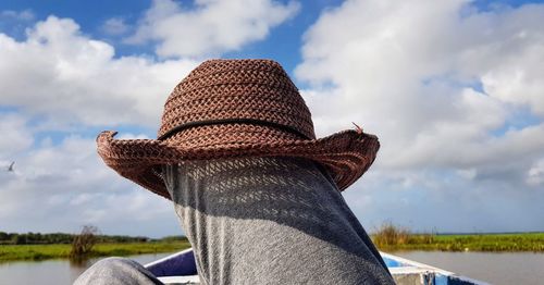 Close up of hat on knee against sky