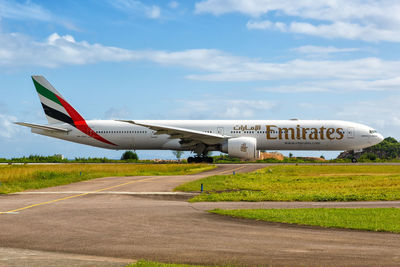 Airplane on airport runway against sky