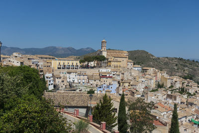 Buildings in city against clear blue sky