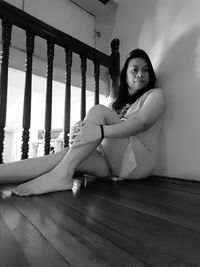 Portrait of woman sitting on floor at home