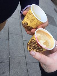 High angle view of hands holding cup
