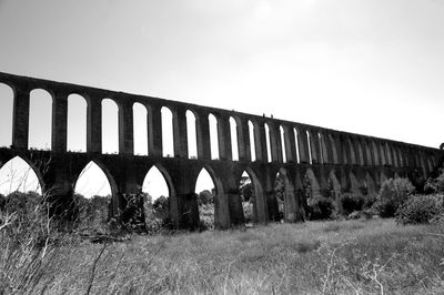 Low angle view of bridge on field against clear sky