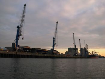 Commercial dock against cloudy sky