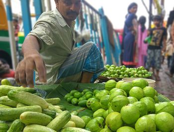 Market vendor selling fruit and vegetable at market stall