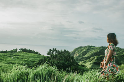 Woman standing by sea against sky