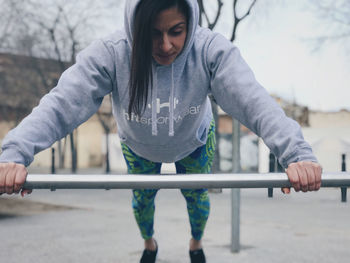 Full length of woman exercising on monkey bars