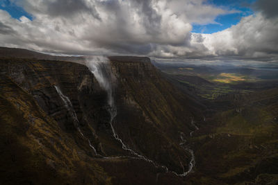 Scenic view of waterfall against sky