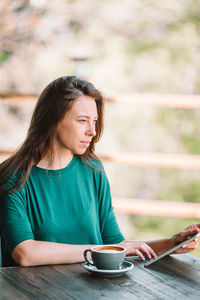 Woman holding coffee cup on table