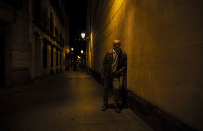 Adult man on street against brick wall with light of street lamp at night. shot in madrid, spain