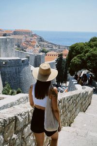 Rear view of woman standing against sea
