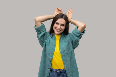 Young woman standing against white background