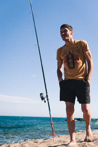 Full length of man standing by sea against clear sky