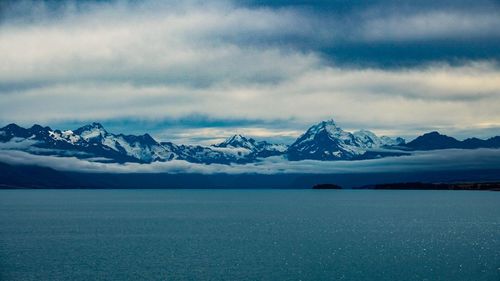 Scenic view of lake and snowcapped mountains against sky