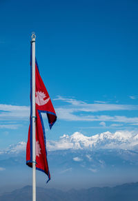 Low angle view of flag against blue sky