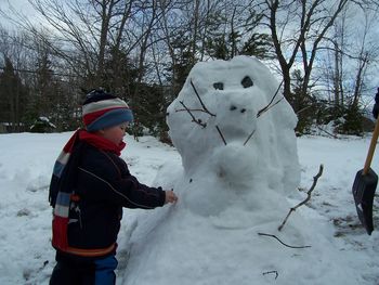 Boy standing on snow covered field