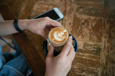 Woman holding coffee cup at table