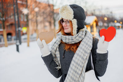 Rear view of woman wearing warm clothing standing in snow