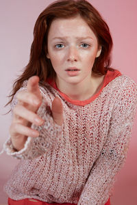 Portrait of beautiful young woman against gray background