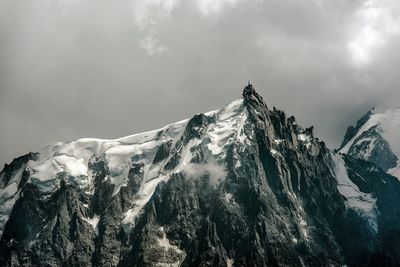 Low angle view of snowcapped mountain against sky