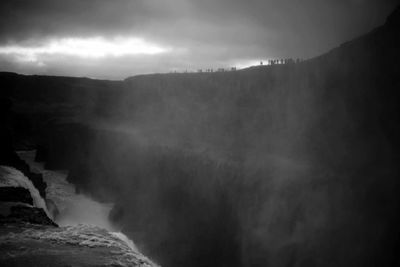 Scenic view of waterfall against sky