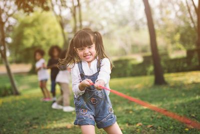 Friends playing tug-of-war at park