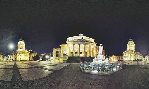 Statue of illuminated cathedral at night